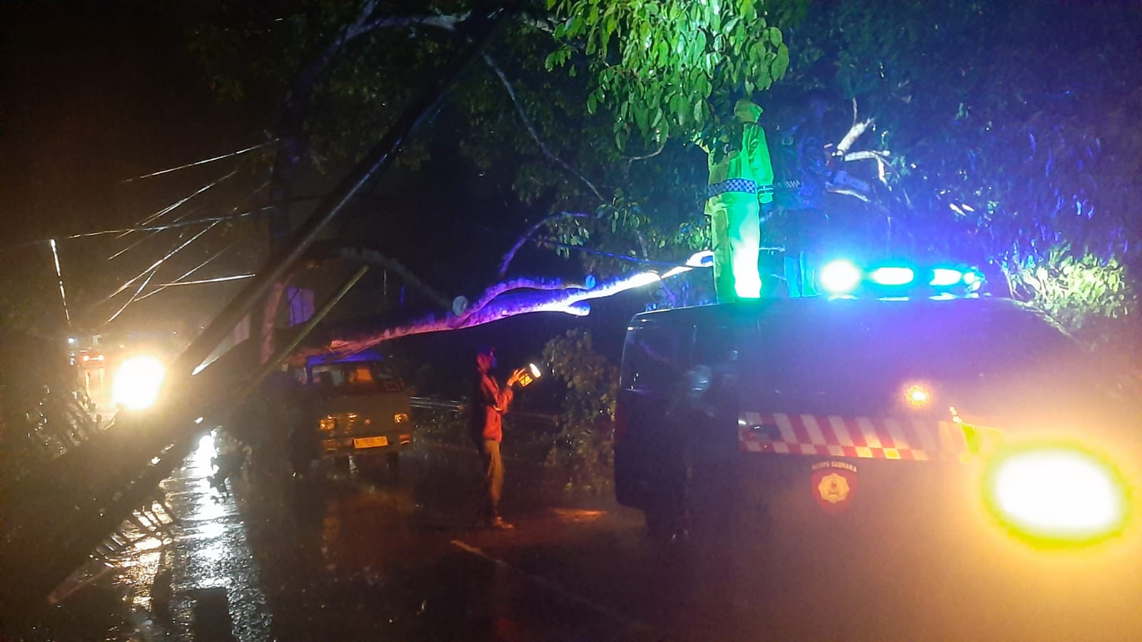 Respon Cepat Anggota Polsek Petir Polres Serang Dini Hari Dalam Mengatasi Pohon Tumbang Ke Jalan Raya